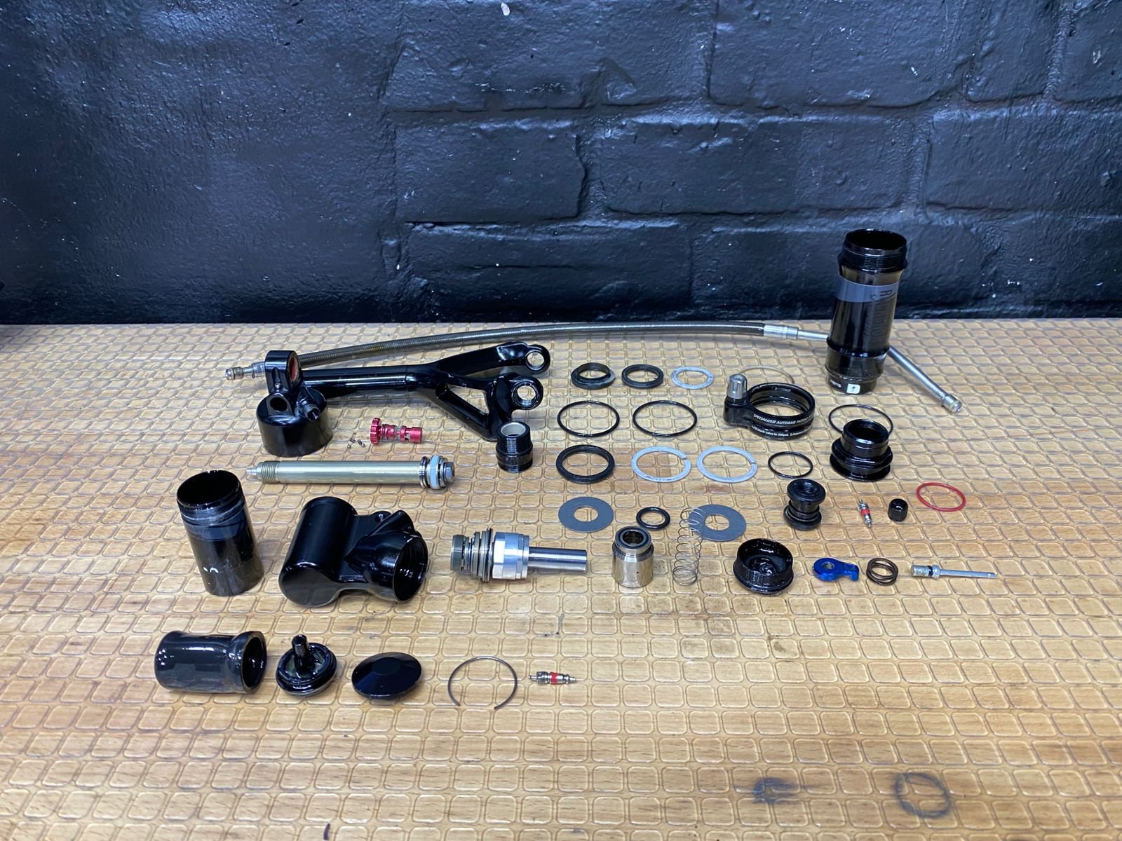 Componentes de suspensión de bicicleta en mesa de trabajo GUS BIKES
